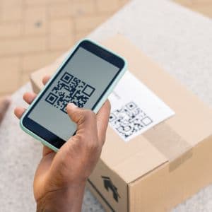 A person scanning a QR code on a shipping box