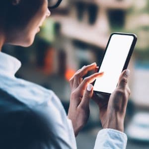 A person with glasses looking at a phone